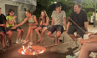 Jugendliche sitzen am Lagerfeuer