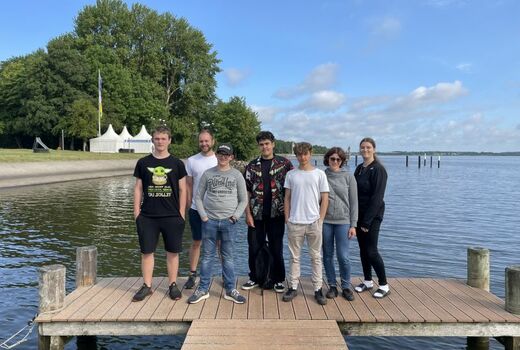 Gruppenfoto mit fünf Schülern, einem Lehrer und einer Lehrerin auf einem Steg.