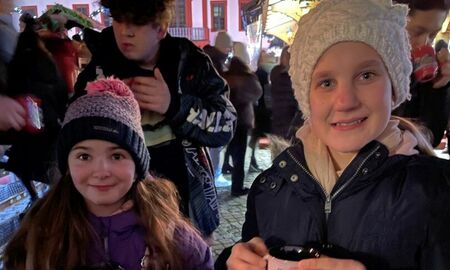 Zwei Mädchen trinken Kinderpunsch auf dem Weihnachtsmarkt