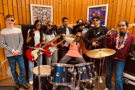 SchülerInnen mit Instrumenten posieren für ein Bandfoto