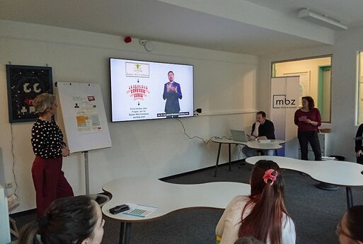 Die InternatsschülerInnen schauen sich den Film auf einem großem Fernseher an.