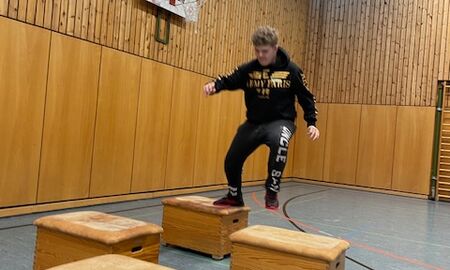 Ein Junge springt über vier Kästen