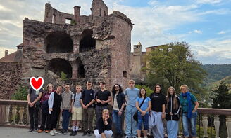 Die gesamte Gruppe steht vor einer Schlossruine.