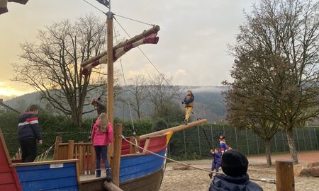 Kinder spielen auf einem großen Piratenschiff auf einem Spielplatz