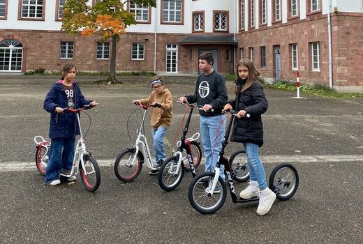 vier Kinder präsentieren die neuen Roller