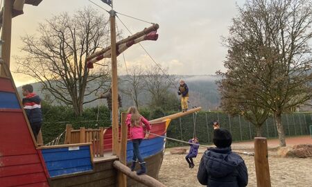 Kinder spielen auf einem großen Piratenschiff auf einem Spielplatz