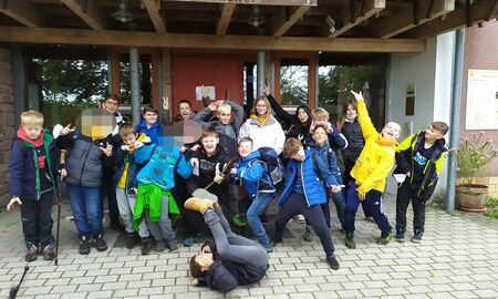 Die Schülerinnen und Schüler der Klassen 4a und 4b posieren albern für ein Gruppenfoto vor einem Hauseingang.
