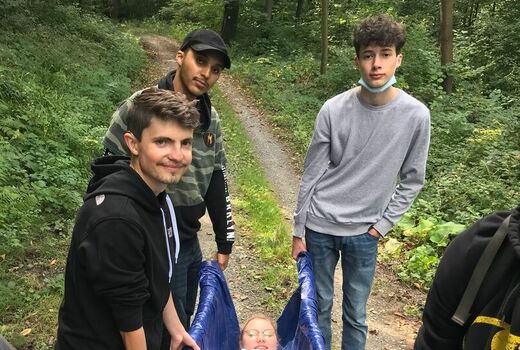 Schülerinnen, Schüler und Lehrer tragen eine Person aus dem