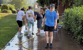 Wasserschlacht mit Bechern, Eimern und Schlauch