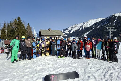 27 SchülerInnen posieren mit ihren LehrerInnen im Halbrund. Sie haben ihre Wintersportausrüstung an.
