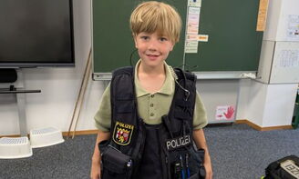 Ein Junge trägt die Polizeiweste