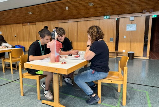Lehrerin und zwei Schüler an einem Tisch