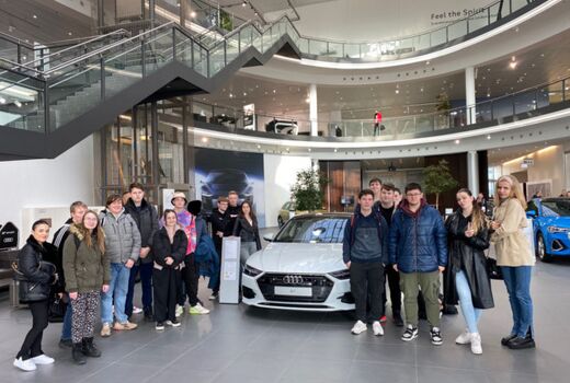 Schülerinnen und Schüler stehen links und rechts aufgestellt vor einem Audi Cabrio