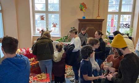 Kinder kaufen mit ihren Eltern Gebasteltes vom Bazar