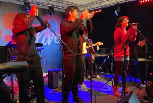 Drei SchülerInnen singen und klatschen