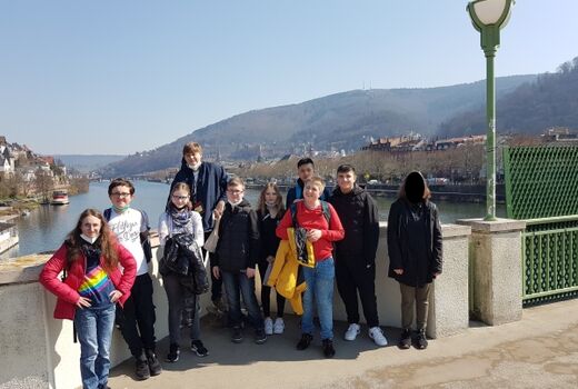 10 Schüler*innen stehen auf der Neckarbrücke, im Hintergrund der Neckar und die Hügel