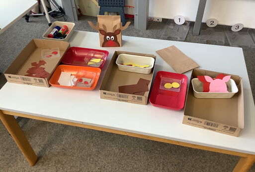 Bastelmaterialien und Vorlage für das Adventskalender-Tütchen in Form einer Papiertüte mit einem Rentier-Kopf drauf