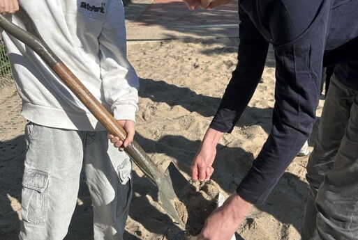Zwei Schüler befüllen Sandsäcke