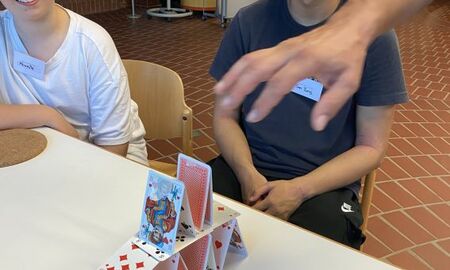 Eine Gruppe baut ein Kartenhaus