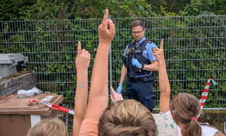 Kinder wollen dem Polizist Fragen stellen