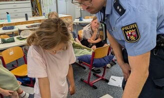 Der Polizist nimmt Fingerabdrücke einer Schülerin