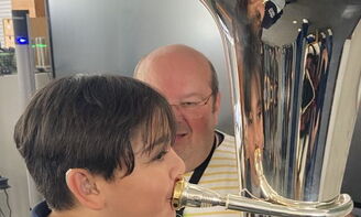 Eine Junge bläst in eine Tuba