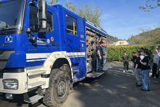 Schüler stehen vor dem Einsatzwagen des THW