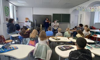 Kinder lauschen den zwei Musikern