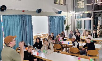 Jugendliche spielen ein Pubquiz. Ein Betreuer moderiert.