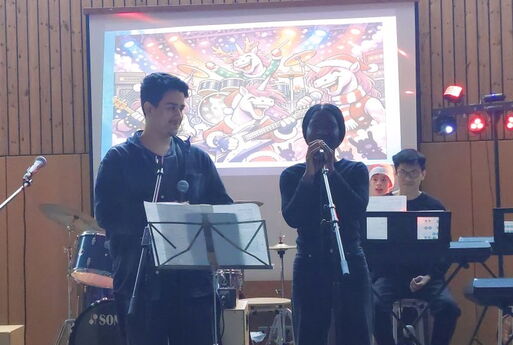 Ein Schüler lächelt und eine Schülerin singt