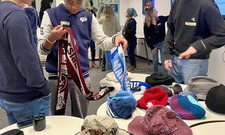 Drei Jungen wählen winterliche Kopfbedeckungen für ihre Präsentation