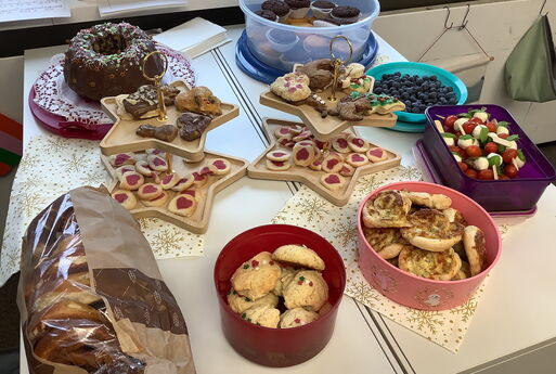 Ein Buffet aus verschiedenen Speisen, wie Brezeln, Plätzchen, Muffins, Kuchen, Blaubeeren, Tomate-Mozzarella-Spieße auf weihnachtlichen Servietten, in Dosen und auf Etageren