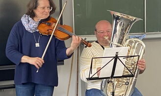 Eine Frau spielt die Geige und ein Mann die Tuba