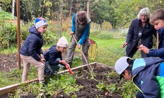 Kinder graben ein Beet um