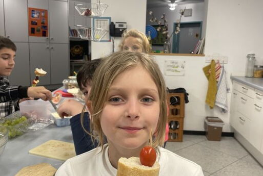 Ein Mädchen mit Brot und Tomaten-Spieß