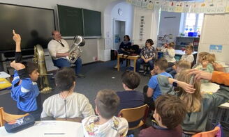 Eine Gruppe Schüler stellt Fragen an die Musiker