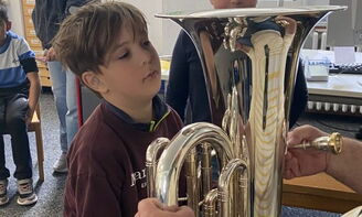 Ein Junge hebt die Tuba hoch